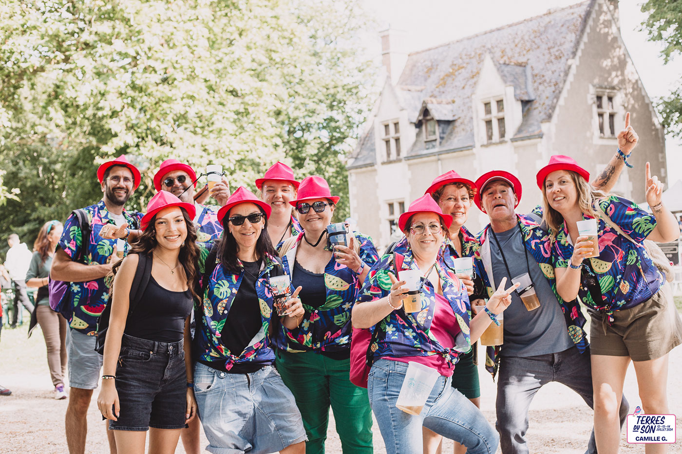 Un groupe de personne munis d'un chapeau de couleur rouge et de chemises à fleurs